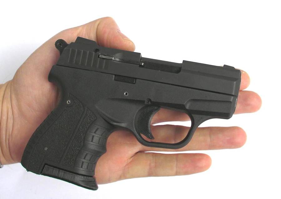 A person holding a small gun in their hand.